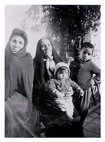 standing next to his mother, grandmother and his little sister